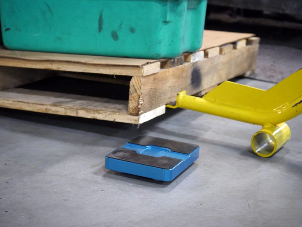 Pry bar lifting a pallet onto a Hudson Hauler